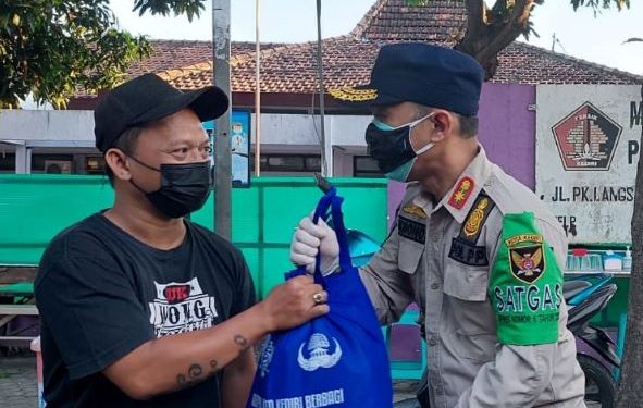 Kasatpol PP Eko Lukmono saat serahkan sembako terbungkus tas bertuliskan KOPRI (Satpol PP)