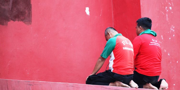 Dua orang karyawan DLHKP Kabupaten Kediri tengah menjalankan Salat Ashar Berjamaah di Tribun Utara Stadion Brawijaya (Nanang Priyo Basuki)