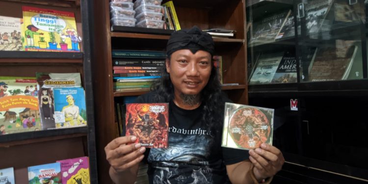 Doni Wicaksono vokalis band Immortal Rites menunjukkan album lagunya (Kintan Kinari Astuti)