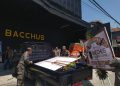 Anggota Satpol PP terlihat mengamankan ucapan berupa karangan bunga di halaman depan Bacchus (Sigit Cahya Setiawan)