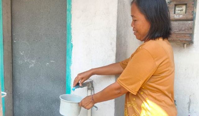 Ibu Semi saat menunjukkan air masih tercemar (Oktavian Yogi Pratama)