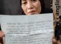 Nuryati menunjukkan surat dibuat suaminya, Alan (Nanang Priyo Basuki)