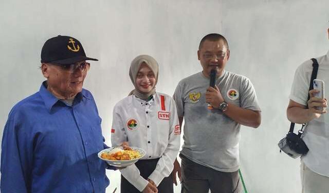 Pak Rohman menerima tumpeng dari Mbak Vinanda sebagai tanda penyerahan rumah (Sigit Cahya Setyawan)